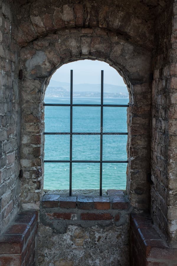 Vista lago, attraverso la finestra di un castello medievale in Italia.